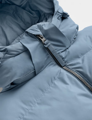 Blue puffer jacket on a light gray background. 