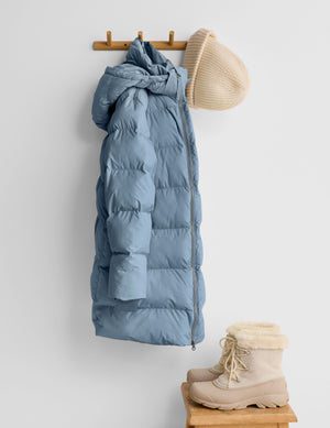 Blue puffer jacket on a light gray background. 