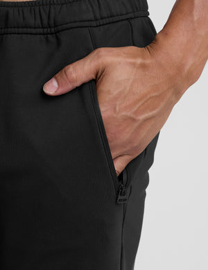 person wearing black pants and white sneakers on a light gray background