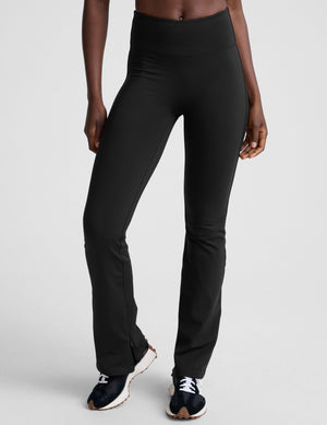 person wearing black high-waisted pants on a white background. 