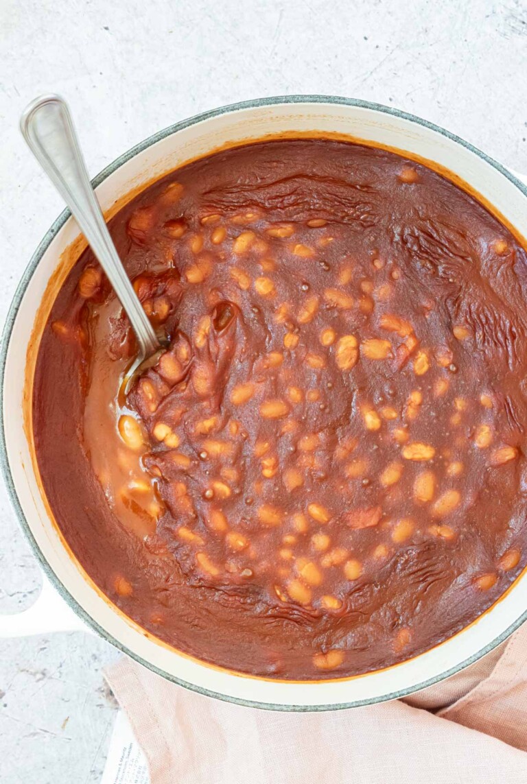 a pot filled with canned baked beans with a serving spoon.