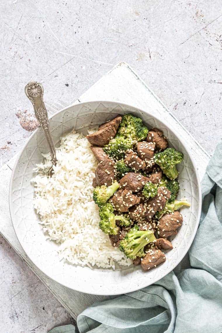bowl filled with instant pot beef and broccoli alongside a serving of white rice