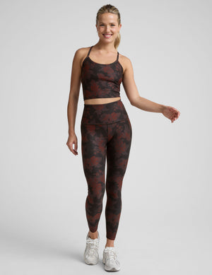 woman wearing a red and brown printed cropped tanks and leggings. 