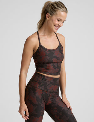 woman wearing a red and brown printed cropped tanks and leggings. 