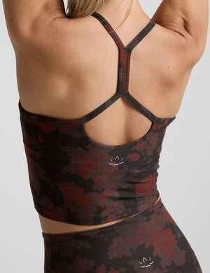 woman wearing a red and brown printed cropped tanks and leggings. 