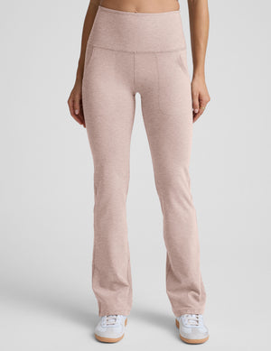 model wearing pink high-waisted bootcut pants with pockets set on a plain background.