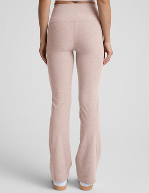 model wearing pink high-waisted bootcut pants with pockets set on a plain background.