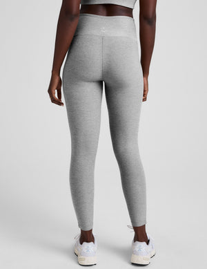 grey high-waisted midi length leggings with white piping details on sides. 