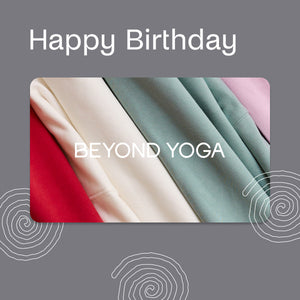 Colorful yoga mats with 'Happy Birthday BEYOND YOGA' text on a gray background